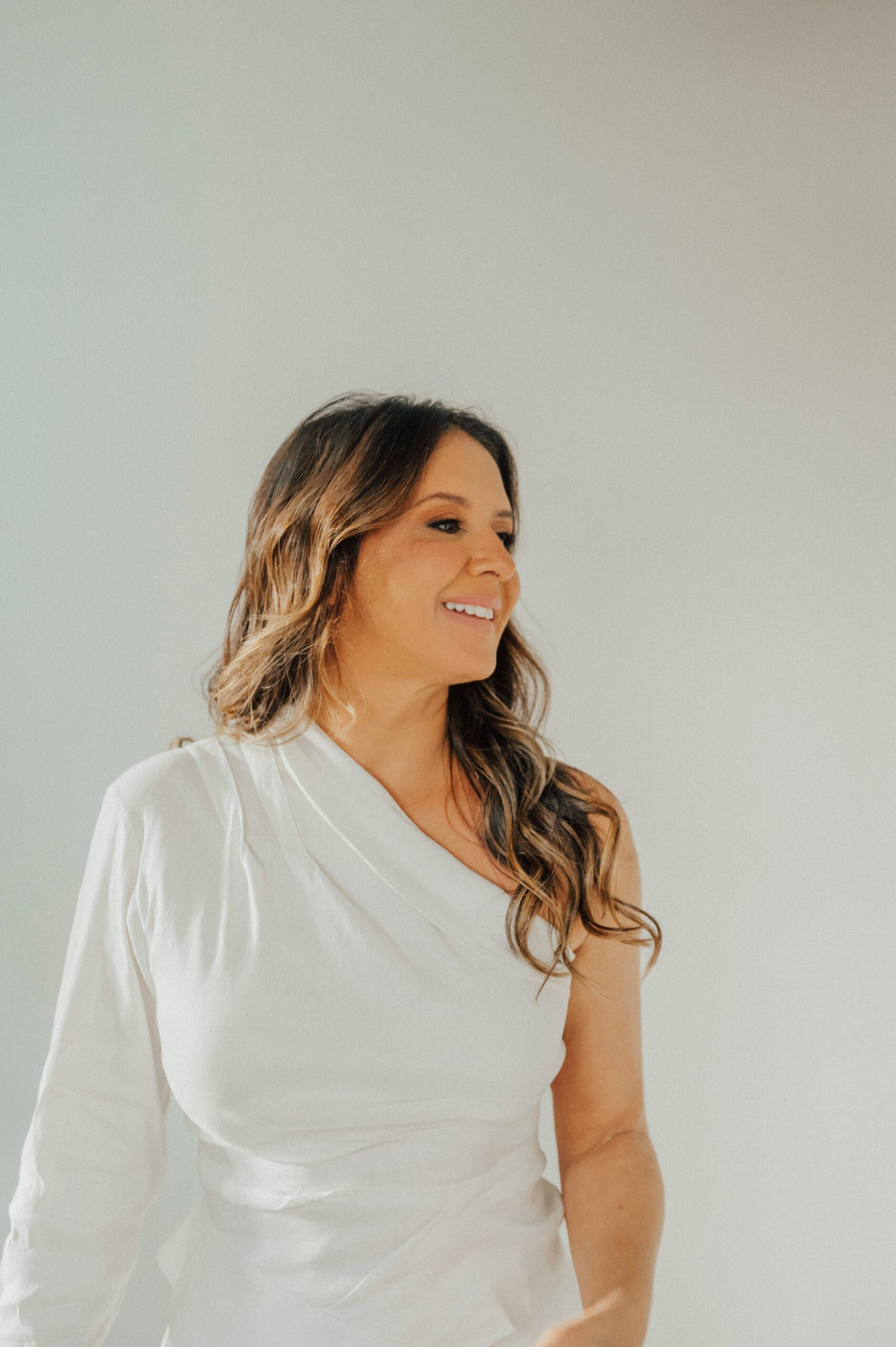 Juliana Mércia sorrindo, vestindo branco